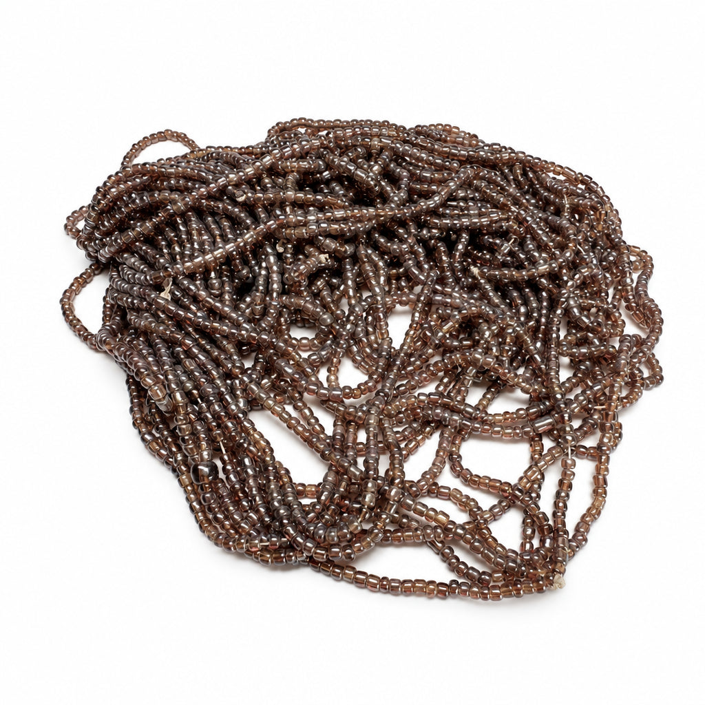A pile of dark brown translucent glass seed beads on a plain white background.