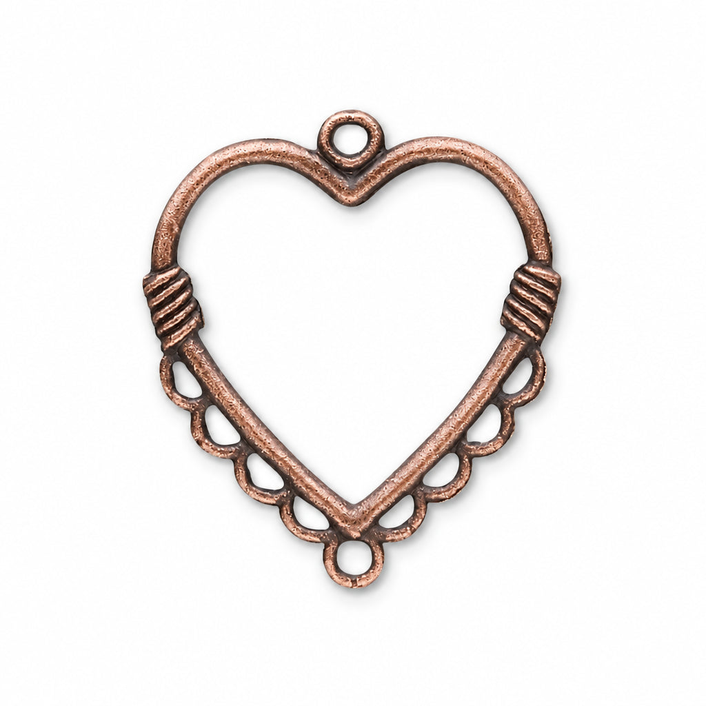 An antique bronze heart-shaped metal jewelry finding or pendant frame with a top loop, decorative side wraps, and scalloped lower edges, shown on a plain white background.