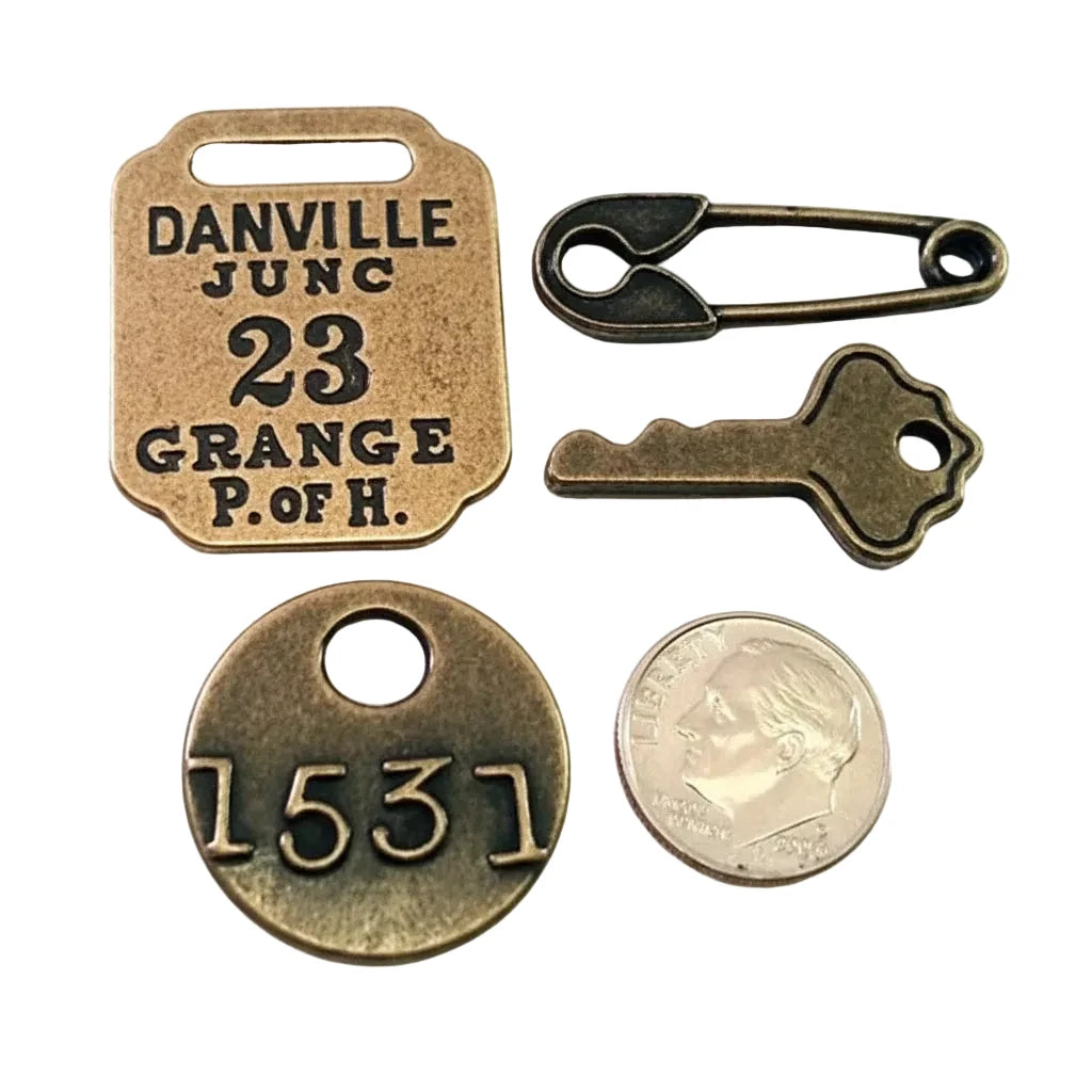 A set of antique-style metal keepsake pieces on a white background, including a square tag engraved with 'DANVILLE JUNC 23 GRANGE P. OF H.