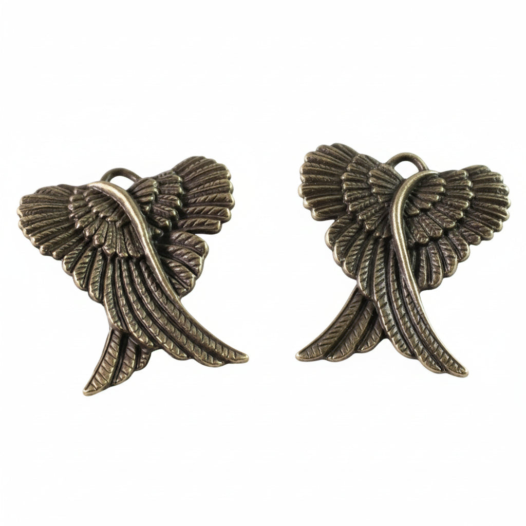 A pair of antique bronze angel wing charms with detailed feather textures, shown on a plain white background.