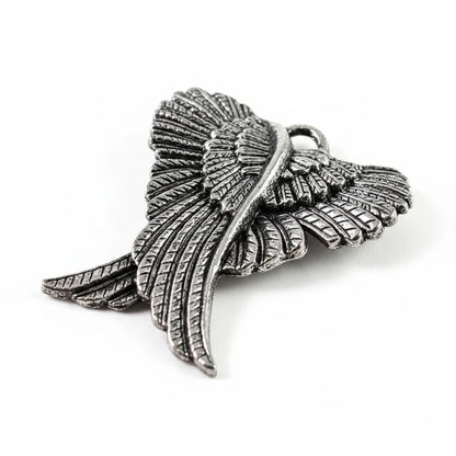 An antique silver metal angel wing pendant or charm, featuring detailed feather textures and a polished central bar, set against a plain white background.