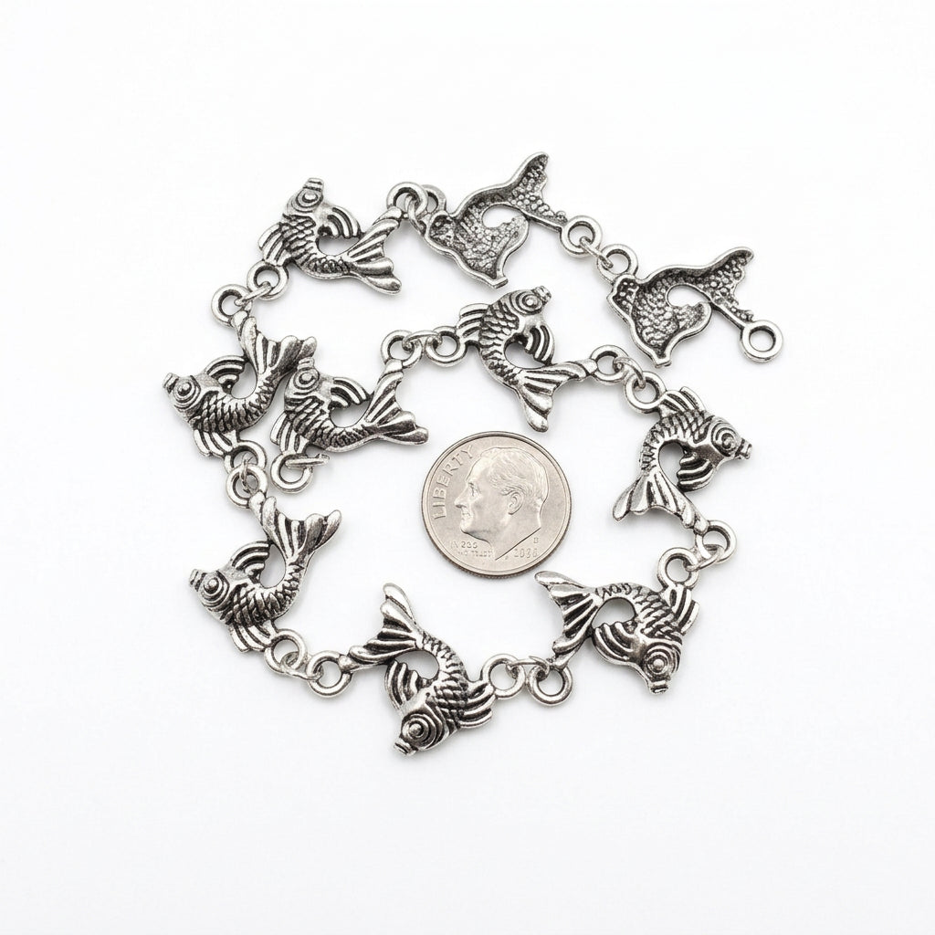 A silver-toned metal CHAIN featuring multiple dangling fish charms, arranged in a circle around a U.S. DIME
