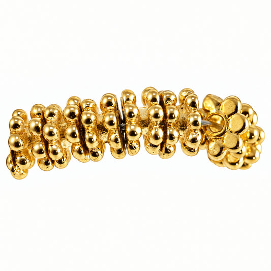 A close-up of a gold  beads, shown against a plain light background.