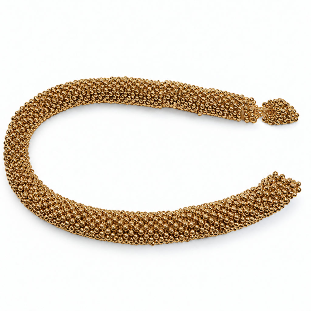 A gold-toned beads with a textured, woven appearance, photographed on a plain white background.