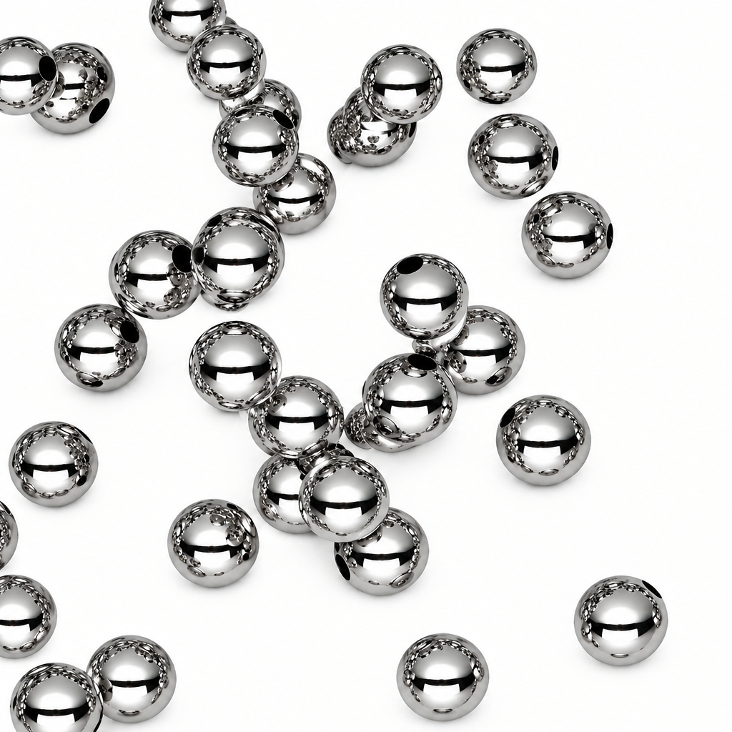 Multiple shiny metallic silver beads scattered on a plain white background.