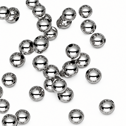 Multiple shiny metallic silver beads scattered on a plain white background.