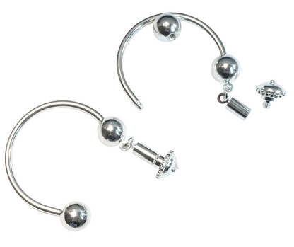 Silver-toned curved hoop earrings with spherical bead details and a small dangling charm, shown on a plain white background.
