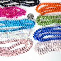 Assorted colorful beads on a white surface with a coin for size reference.