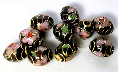 Decorative beads with black, gold, pink, and green colors on a white background