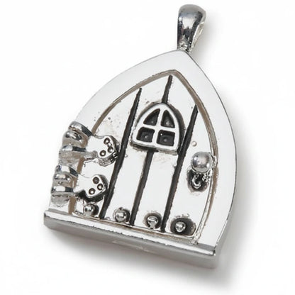 A silver fairy door pendant charm with a gothic-style door design, small silver keys, and a bail at the top, shown on a plain white background.