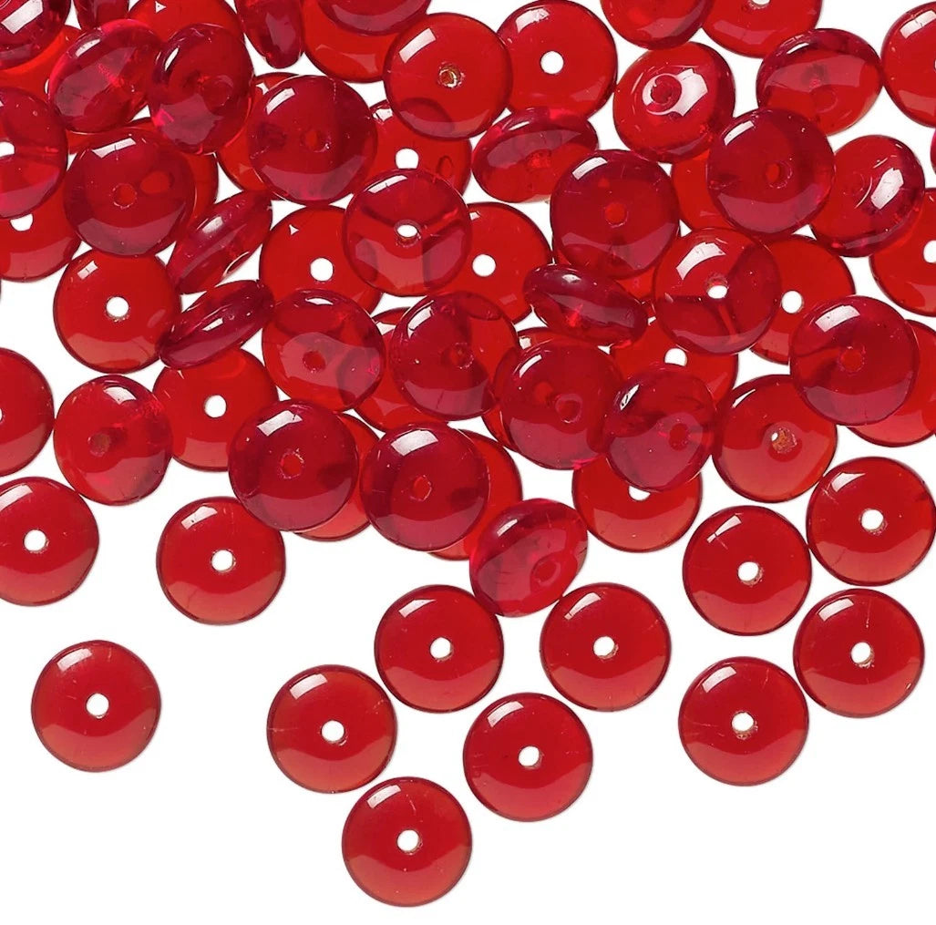 Red translucent acrylic flatback beads with a single hole, scattered on a white background.