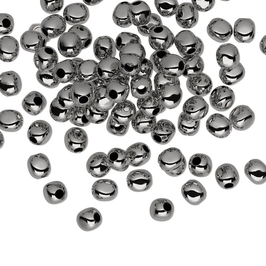 A pile of small, shiny metallic silver beads scattered on a plain white background.