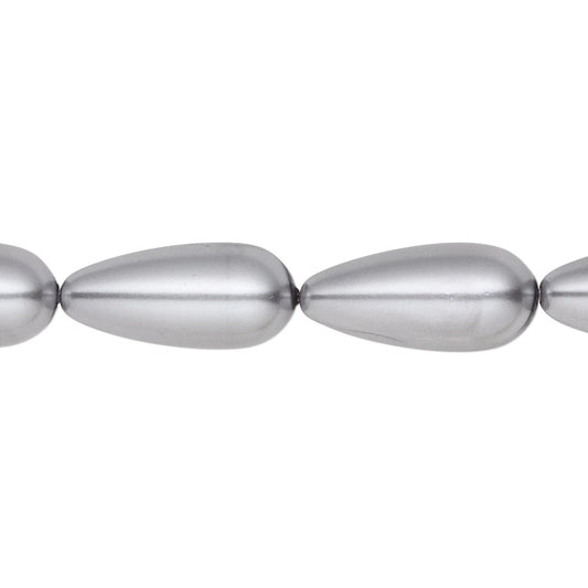 A close-up of metallic silver teardrop-shaped beads on a plain white background.