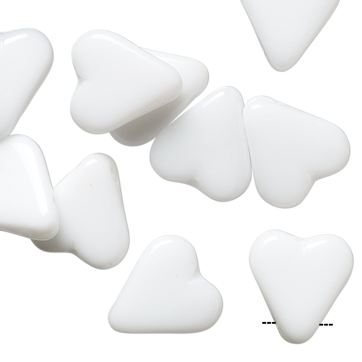 White heart-shaped craft beads scattered on a plain white background.