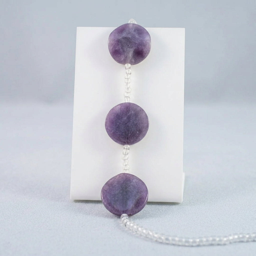 Purple GLASS bead garland with three large polished COIN beads and clear faceted beads, shown against a plain white background.