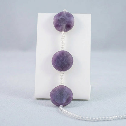 Purple GLASS bead garland with three large polished COIN beads and clear faceted beads, shown against a plain white background.