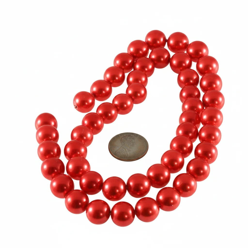 Red glossy pearl beads arranged in loops on a white background, with a coin placed in the center for scale.