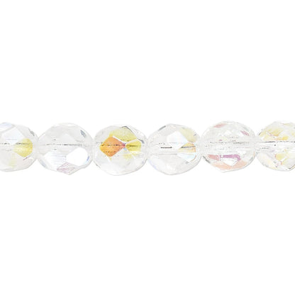 A close-up of faceted clear glass beads with a subtle iridescent yellow and pink cast, strung horizontally on a white background.
