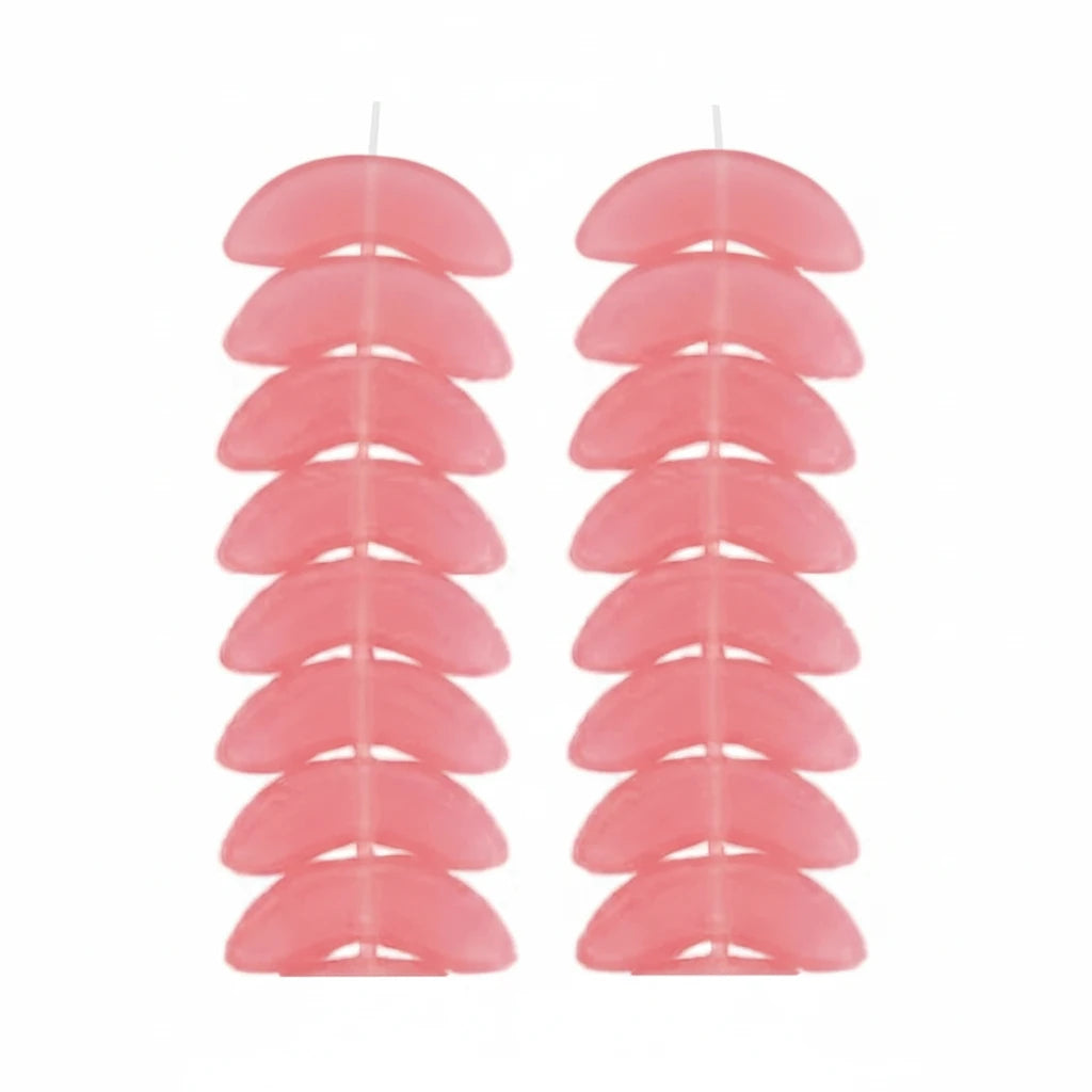 Two vertical rows of small translucent pink crescent-shaped pieces arranged side by side on a white background.