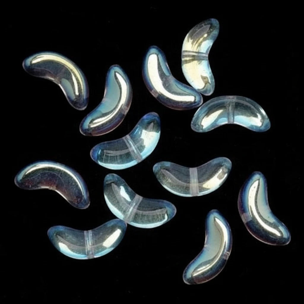Ten small, glossy, crescent-shaped translucent beads with a light blue iridescent sheen scattered on a solid black background.