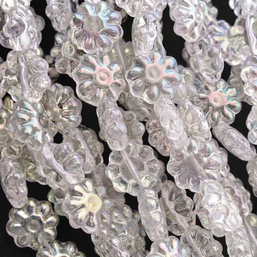 Close-up of iridescent flower-shaped beads on strands, showing a clear, rainbow-prismatic finish against a black background.
