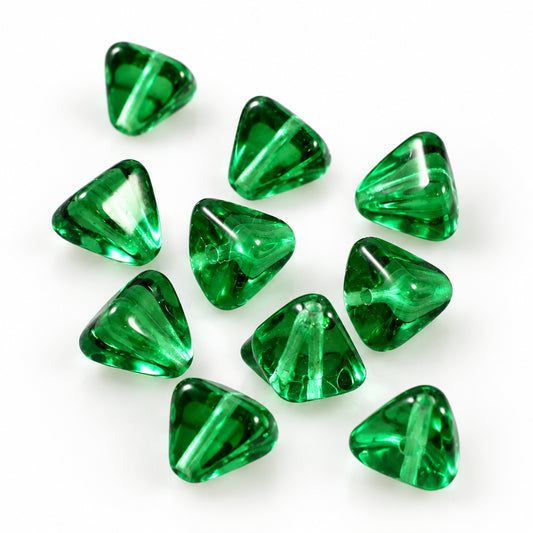 A pile of translucent green glass cabochons with a faceted, diamond-like shape on a plain white background.