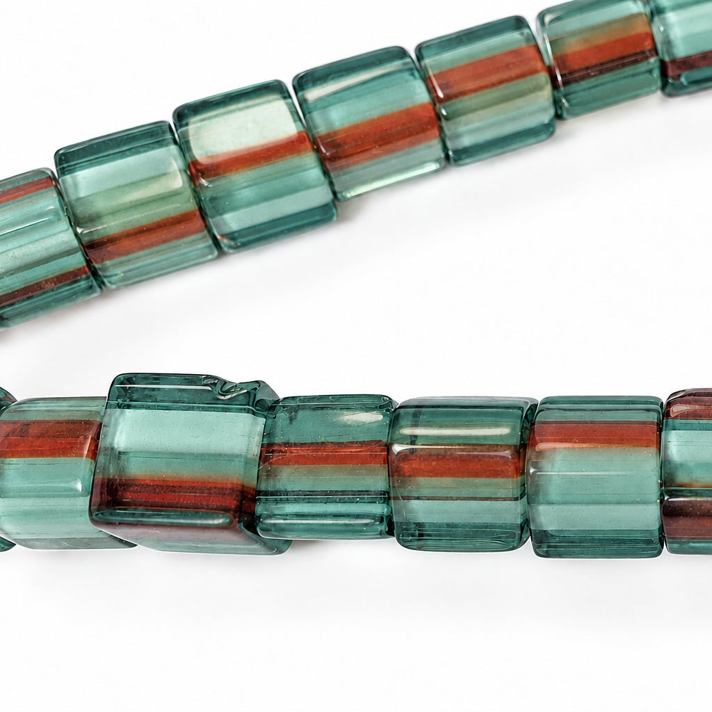 Close-up of a strand of faceted rectangular beads with horizontal stripes of teal green, translucent white, and reddish-brown on a white background.