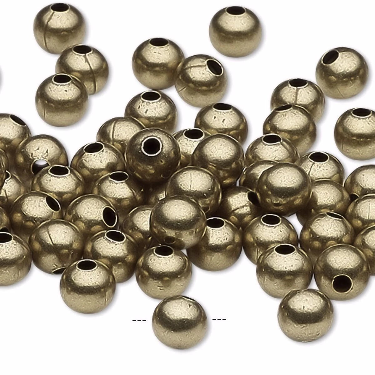 A pile of metallic gold round spacer beads with central holes, scattered on a plain white background.