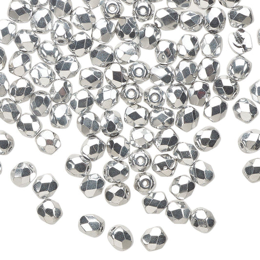 A pile of small silver faceted beads scattered on a plain white background.