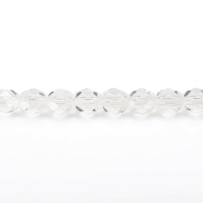 A close-up horizontal line of faceted clear glass beads on a plain white background.