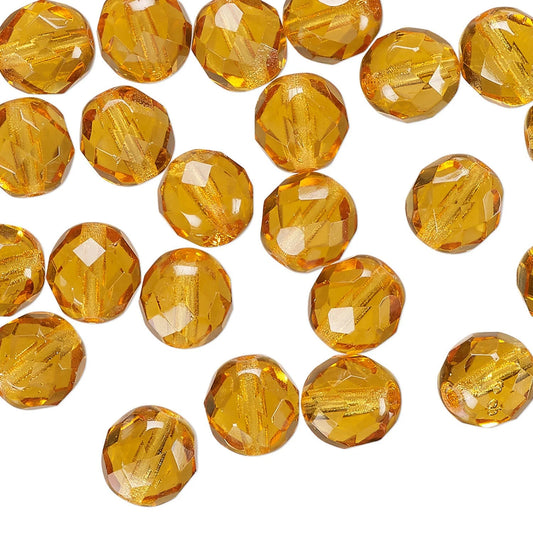 Faceted round amber glass beads scattered on a plain white background.