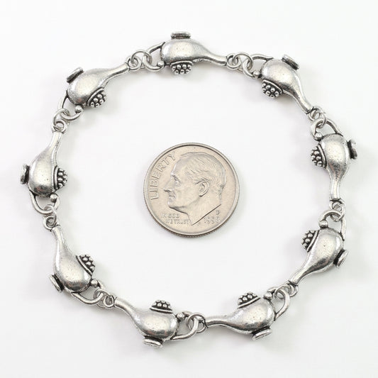 A silver-toned metal bracelet with a repeating fish-link design, shown on a plain white background 