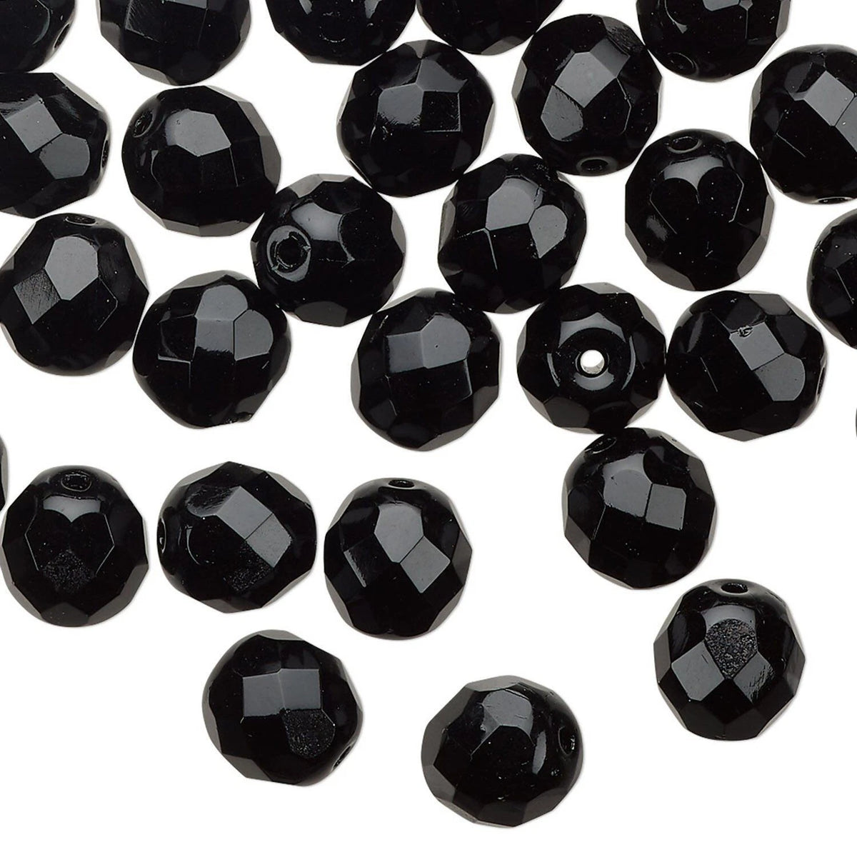 Black faceted round beads scattered on a plain white background.