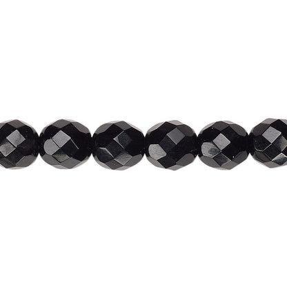 Faceted black beads strung along a thin cord, shown in a close-up horizontal line against a plain white background.