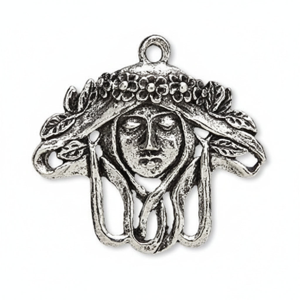 An antique silver-tone metal charm shaped like a Medusa head with flowing hair and a decorative headdress, shown on a plain white background.