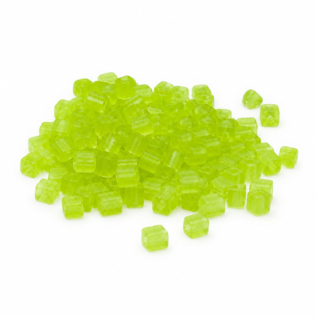 A pile of small translucent cube-shaped seed beads in a bright lime green color, scattered on a plain white background.