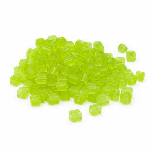 A pile of small translucent cube-shaped seed beads in a bright lime green color, scattered on a plain white background.