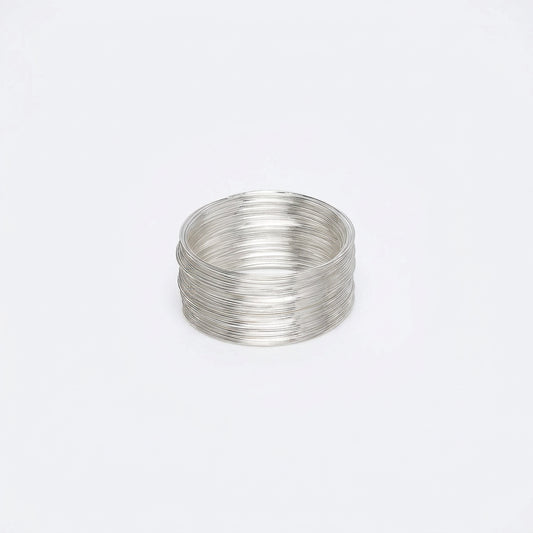 Spool of silver MEMORY wire on a white background