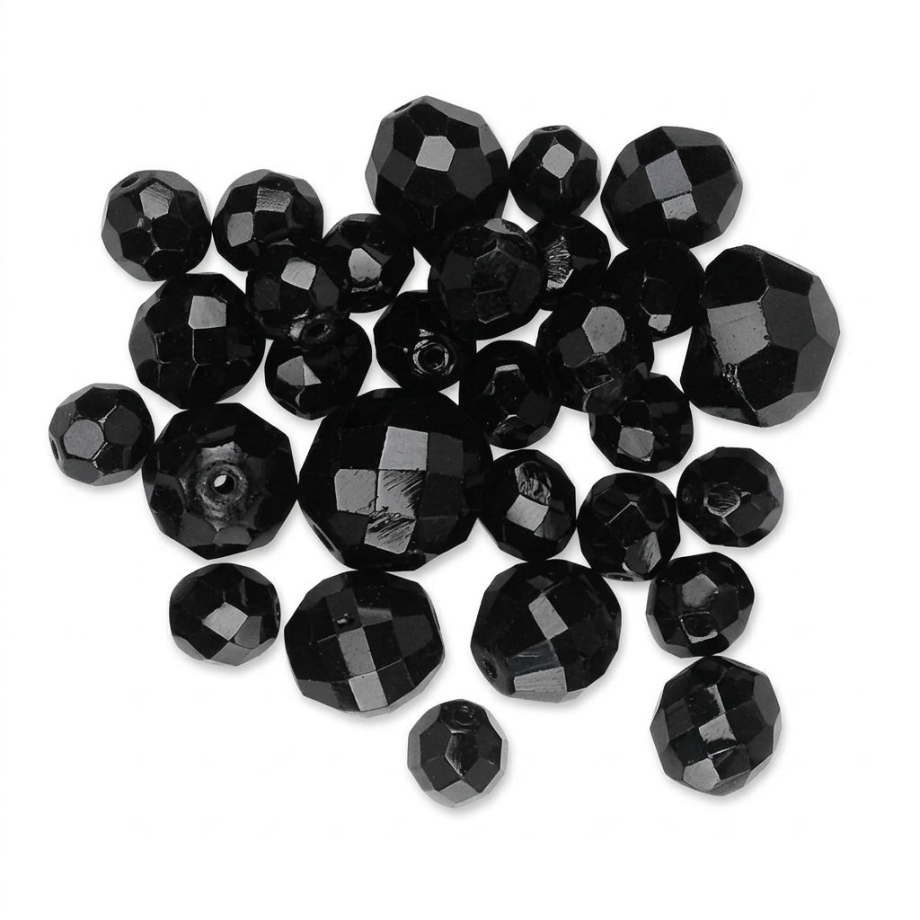 A pile of faceted black glass beads on a plain white background.
