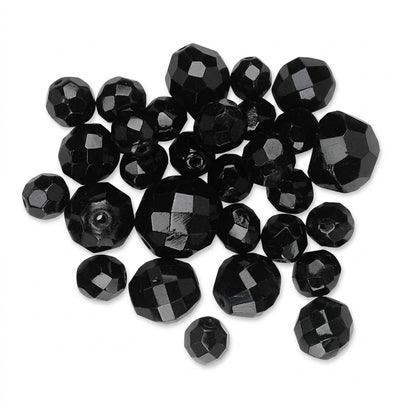 A pile of faceted black glass beads on a plain white background.