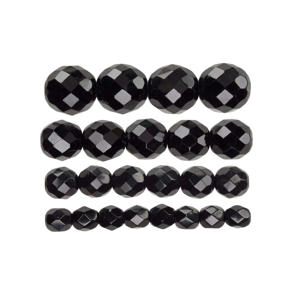 Faceted black beads arranged in horizontal rows on a white background.