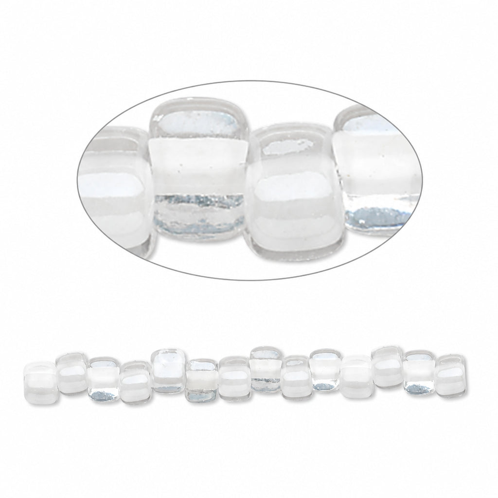 Clear glass seed beads with a rounded square shape, shown in a close-up oval detail view and as a single strand against a white background.