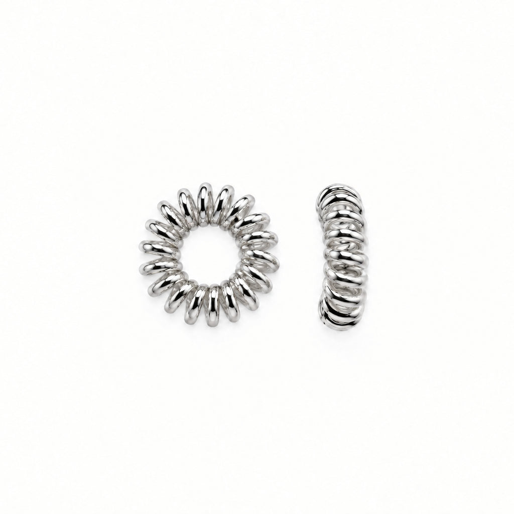 Two small silver-toned metal spacers, one circular with a sunburst pattern and one twisted coil-shaped, shown on a plain white background.