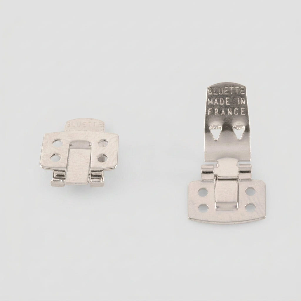 Two silver metal hinge SHOE CLIP latches on a plain white background, one showing the front and the other showing the back with 'BLUETTE MADE IN FRANCE' stamped on it.
