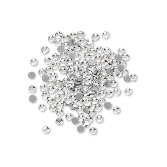 A pile of small round silver rhinestones with flat backs, scattered on a plain white background.