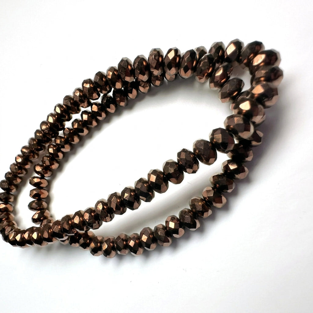 Faceted dark brown beads arranged in a loose loop on a plain white background.