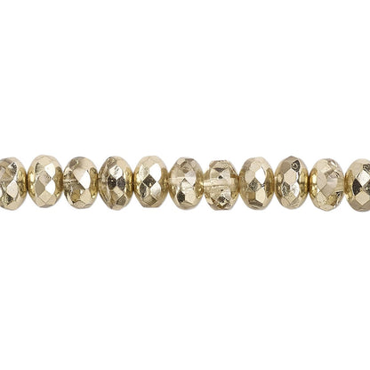 A close-up horizontal line of faceted gold beads on a plain white background.