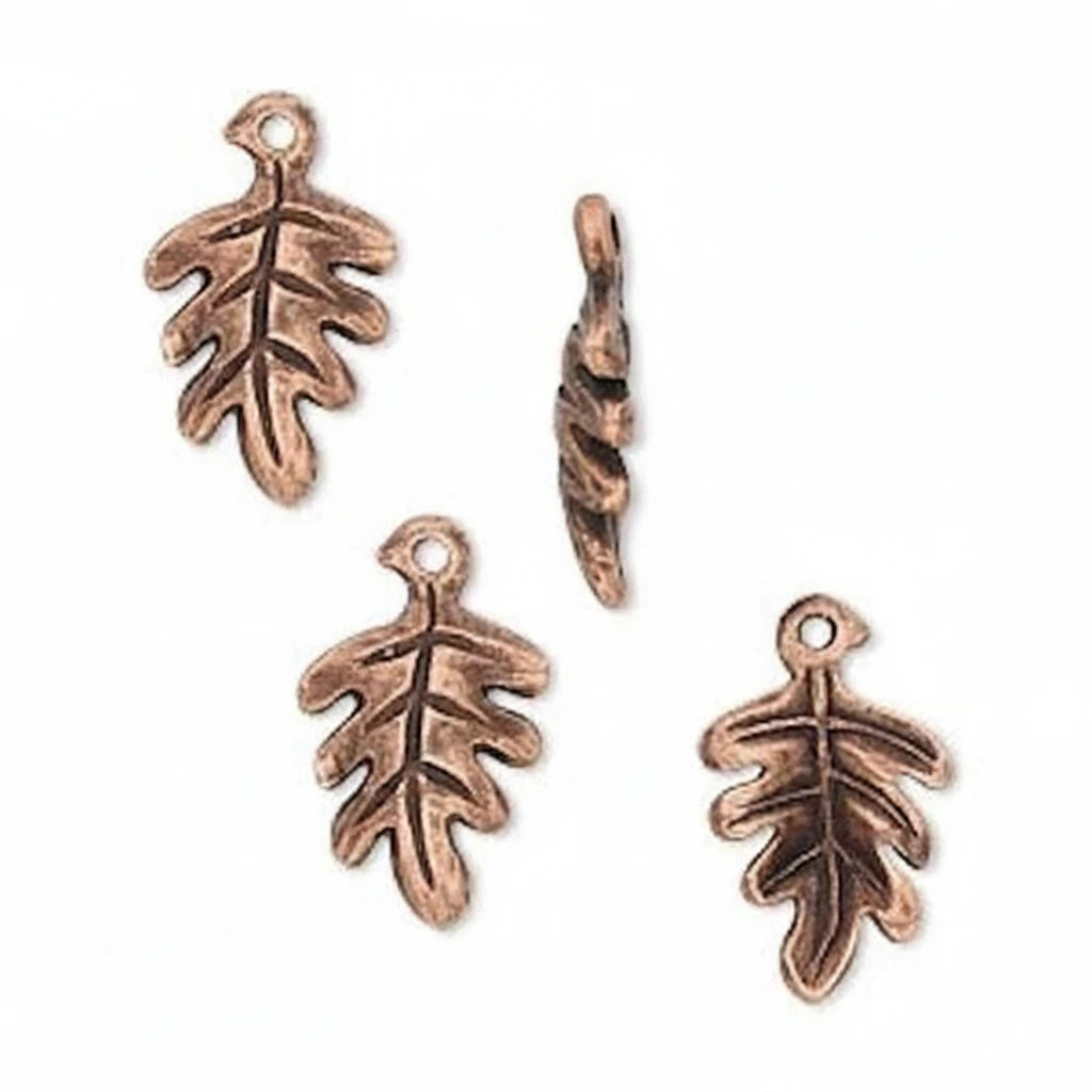 Four small leaf-shaped metal charms with a loop at the top, shown on a plain white background. Three are shaped like oak leaves and one is a twisted leaf charm.