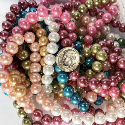A pile of multicolor faux pearl bead strands in pink, gold, white, blue, green, and burgundy, with a US quarter coin placed in the center for scale.