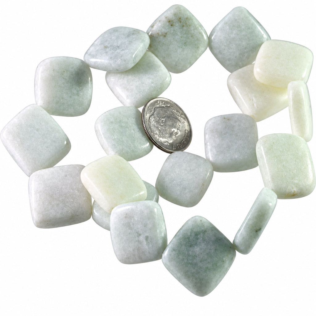 A group of rounded, polished stone tiles in various shades of white, pale green, and light gray, arranged on a white background with a US quarter coin in the center for scale.